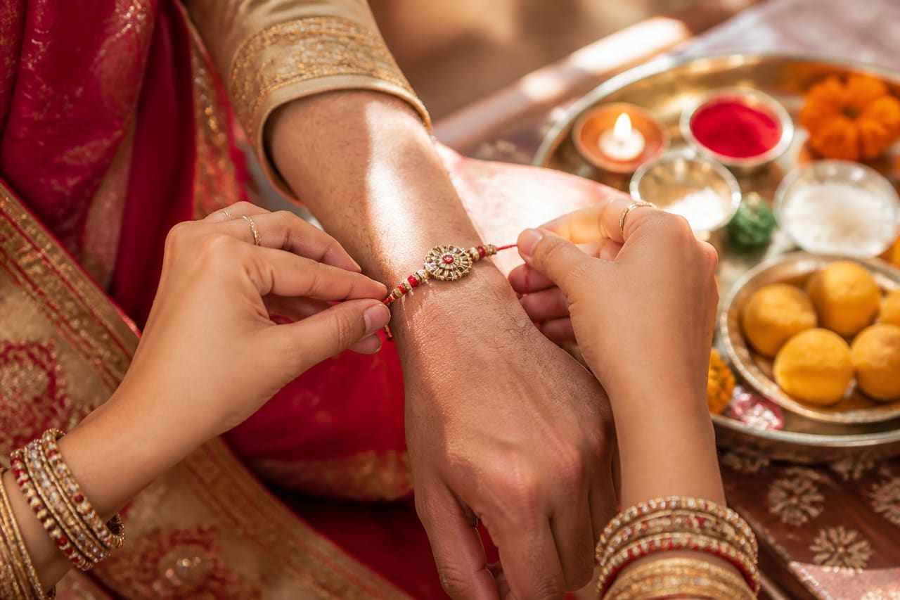 Sister Tying Rakhi Thread on Brother's Wrist During Raksha Bandhan