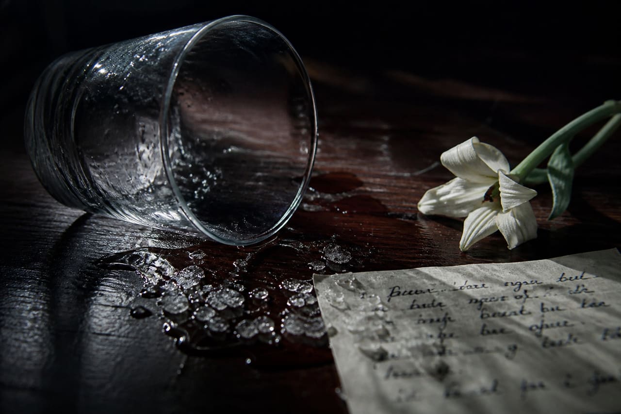 Spilled Glass and Chemical Residue on Dark Wooden Table
