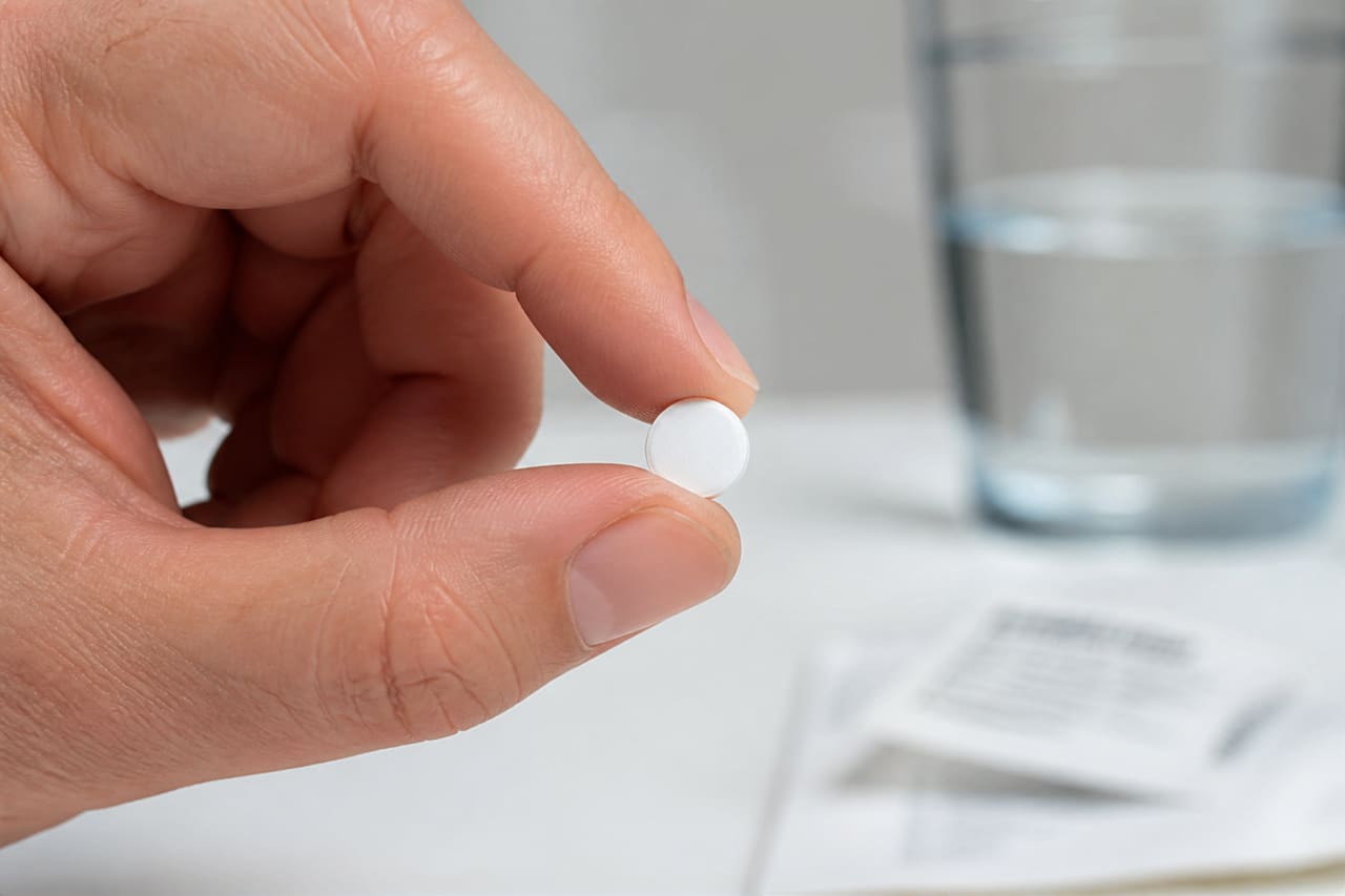 Hand Holding a Nitro Sublingual Dose Tablet