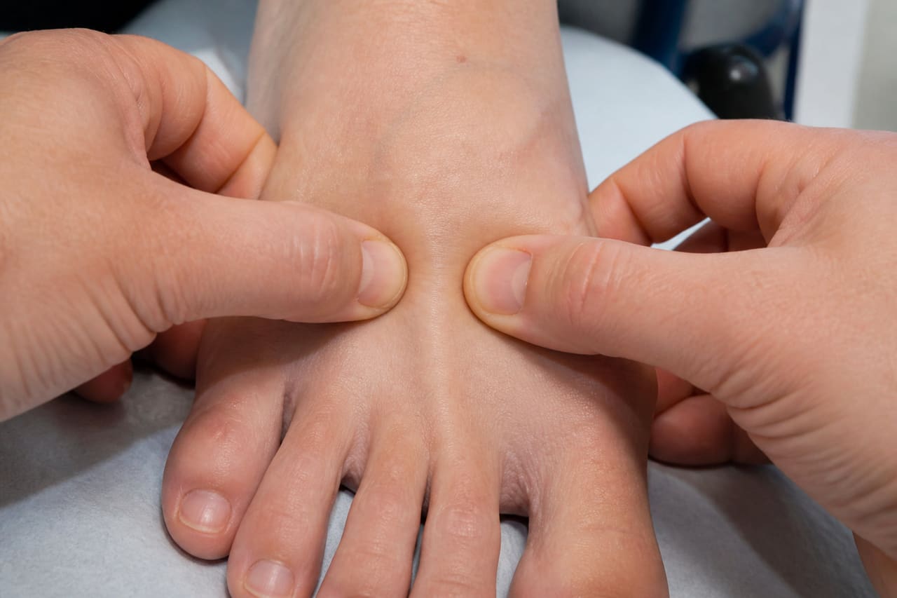Physician Performing Mulder's Sign Examination on a Patient's Foot