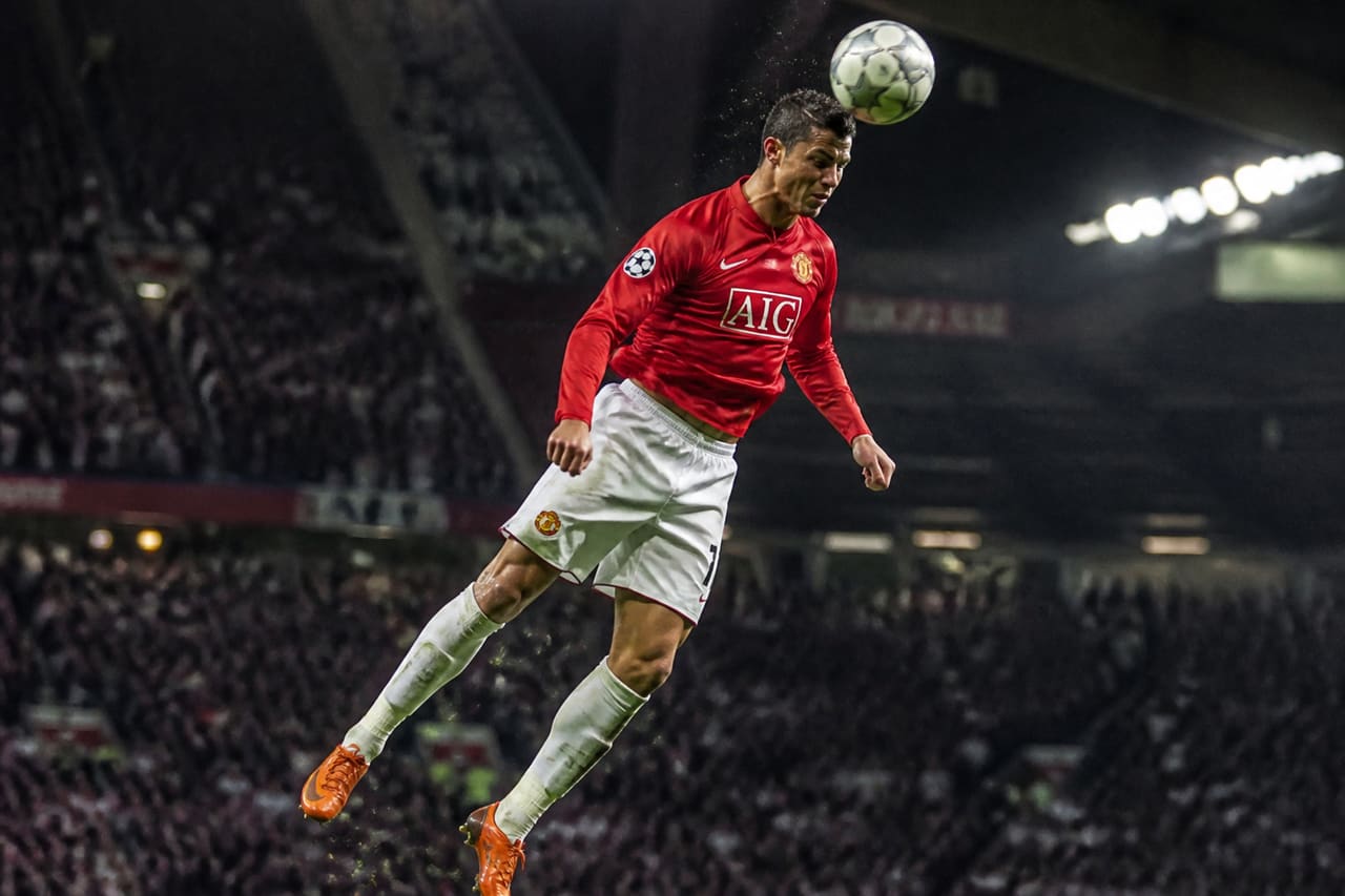 Professional Soccer Player Jumping for a Header in a Stadium
