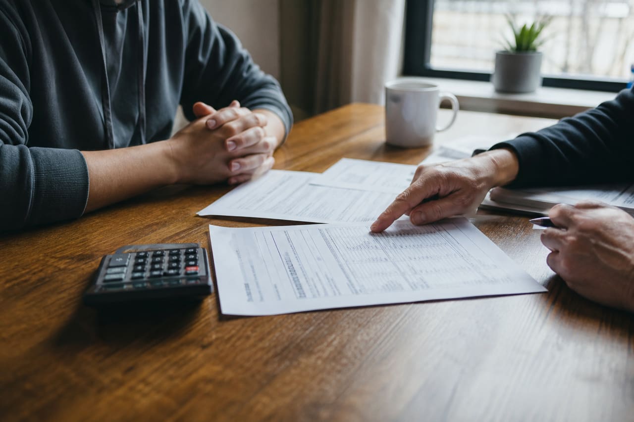Landlord and Tenant Discussing Rent Increase Over Documents