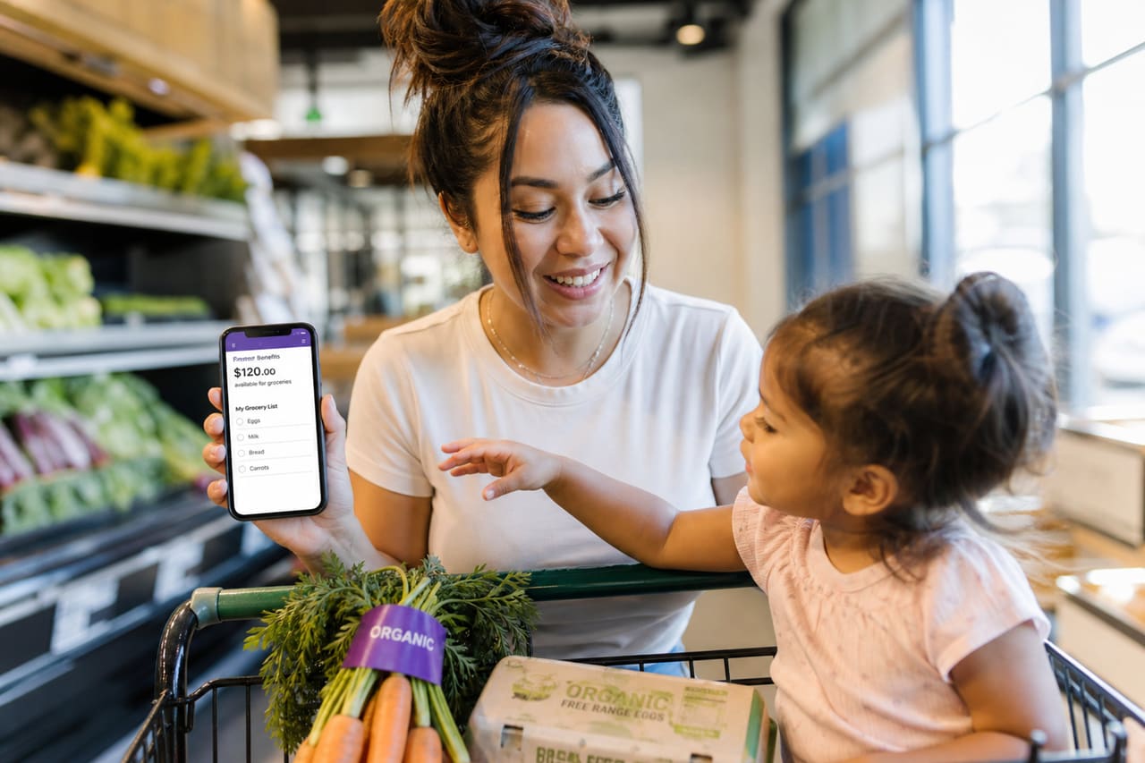 Mother and Toddler Shopping for Fresh Produce with Benefit App
