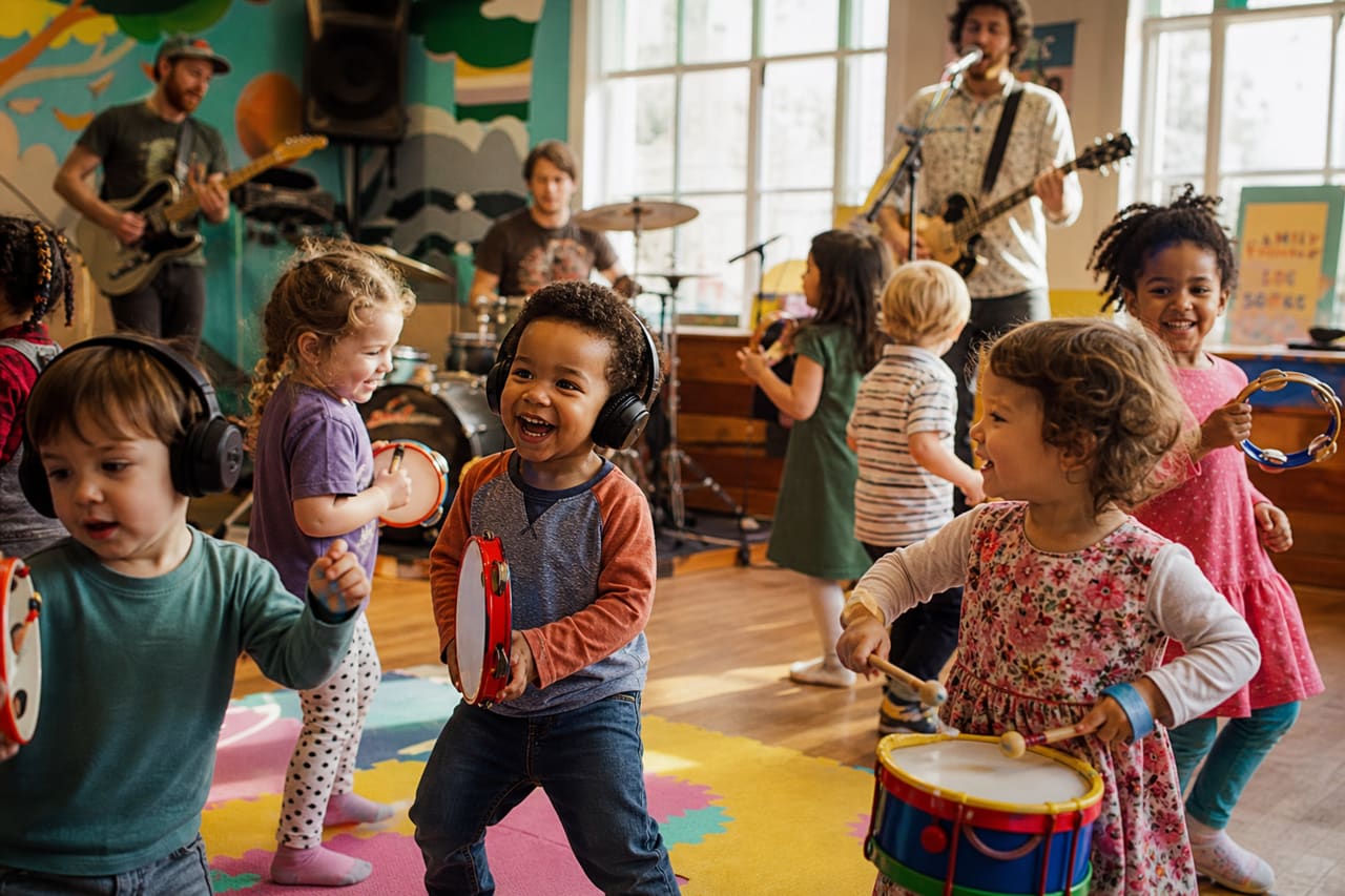 Toddlers Dancing and Playing Instruments at a Community Music Event