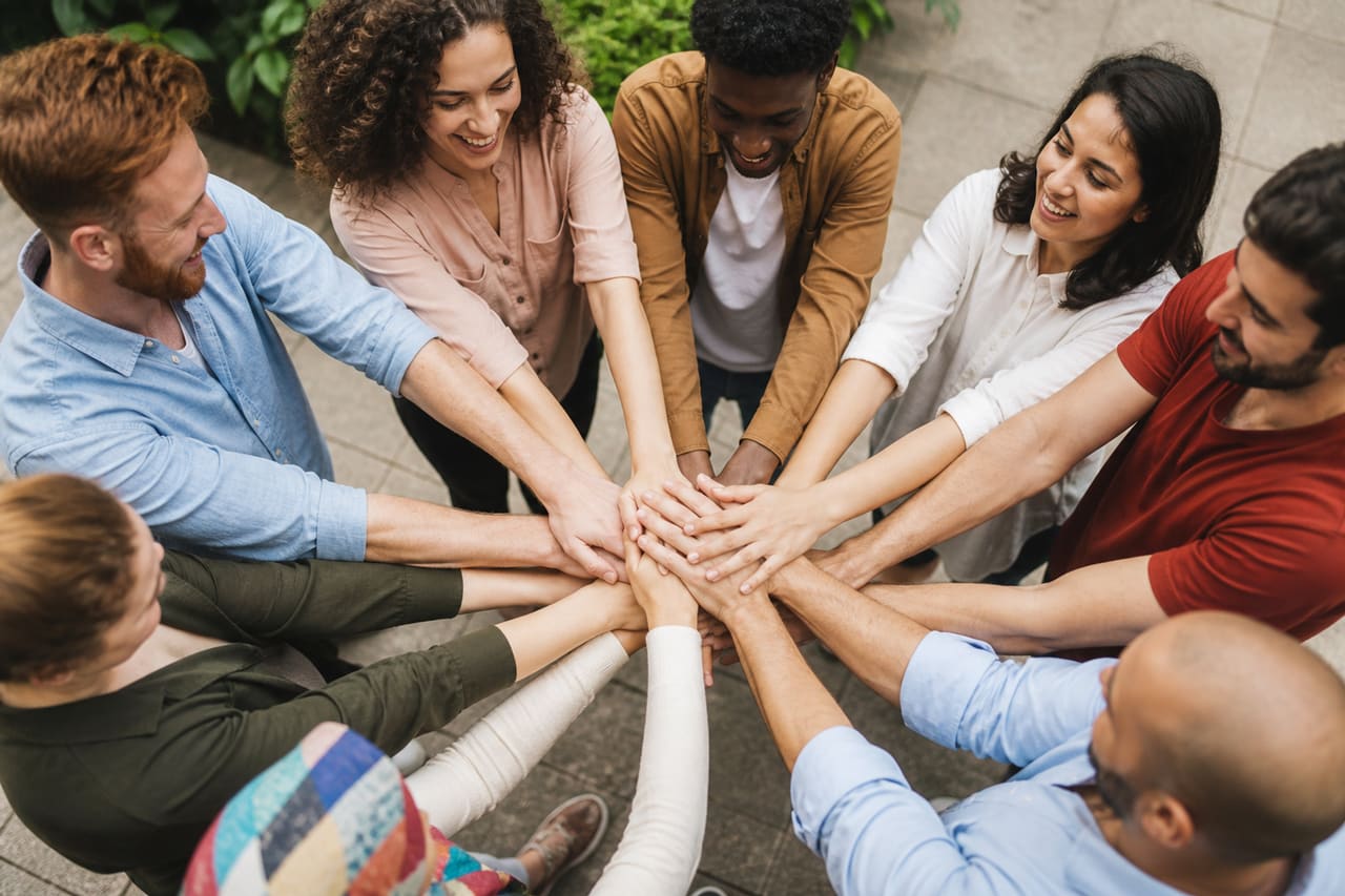 Diverse Group of People Joining Hands in Unity