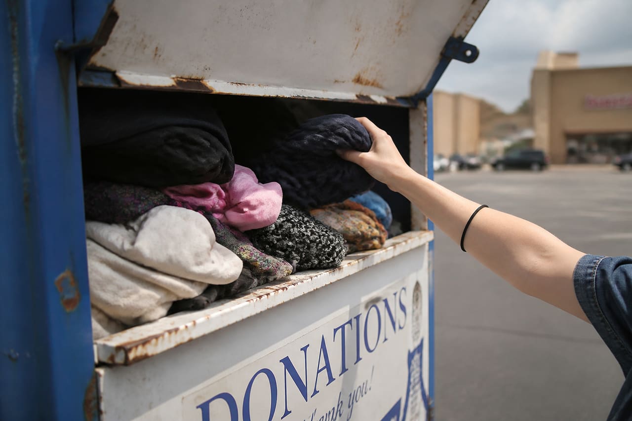 Person Removing Item from Donation Bin at Goodwill
