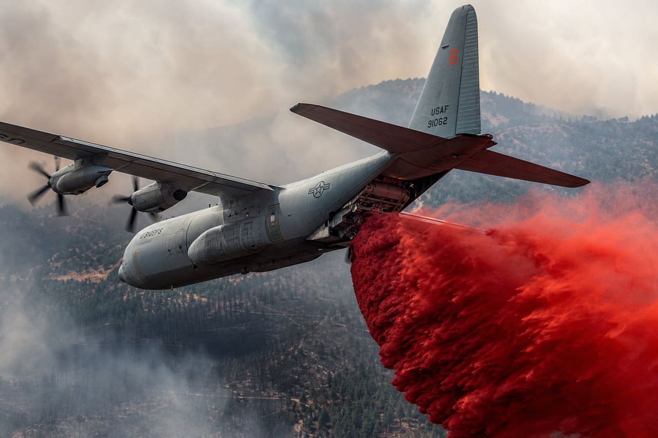 C-130 Aircraft Dropping Red Fire Retardant Over Forest Fire