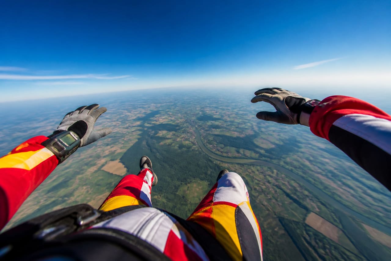 Skydiver in Freefall Over Rural Landscape
