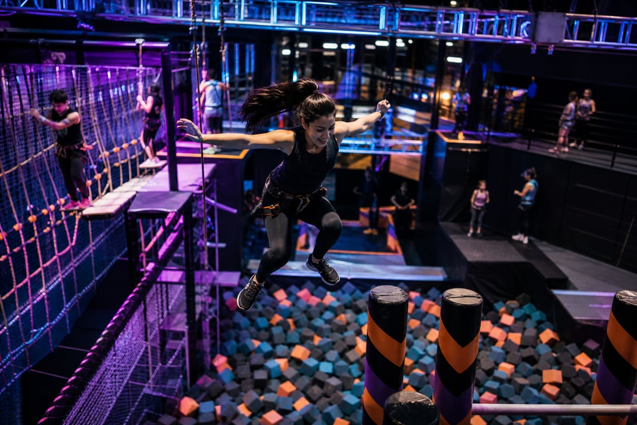 People Navigating a High Ropes Course at an Indoor Adventure Park