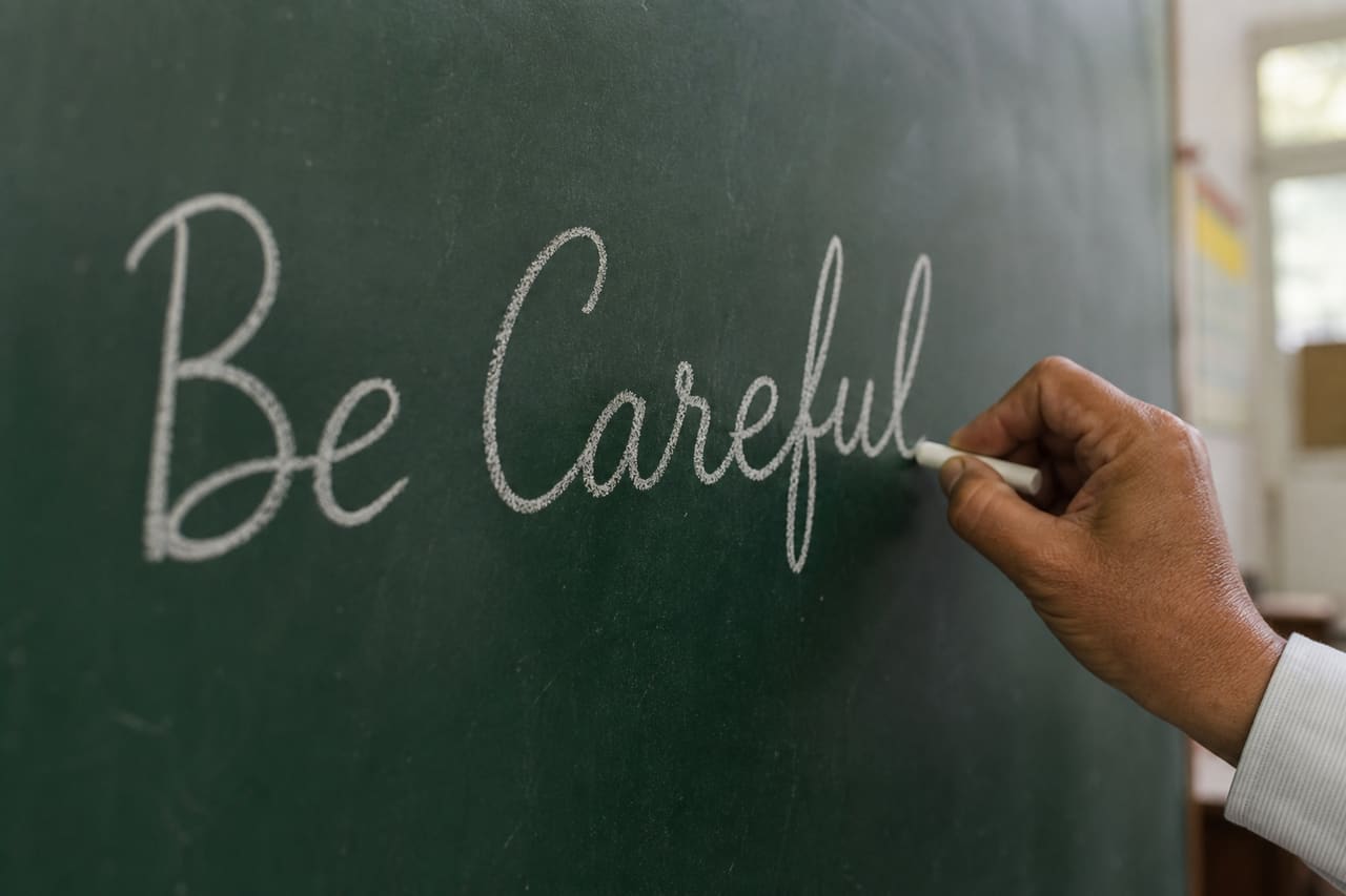Teacher Writing Be Careful on a Green Chalkboard