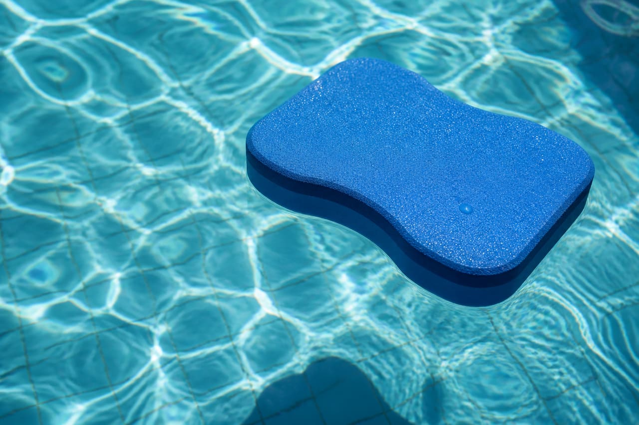 Blue Pool Foam Floating on Clear Swimming Pool Water