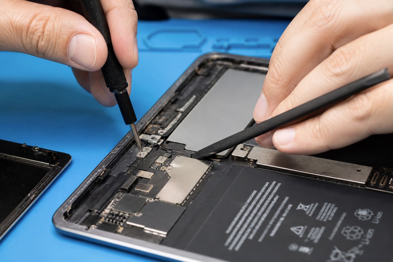 Professional Technician Repairing an Ipad Screen in a Modern Workshop