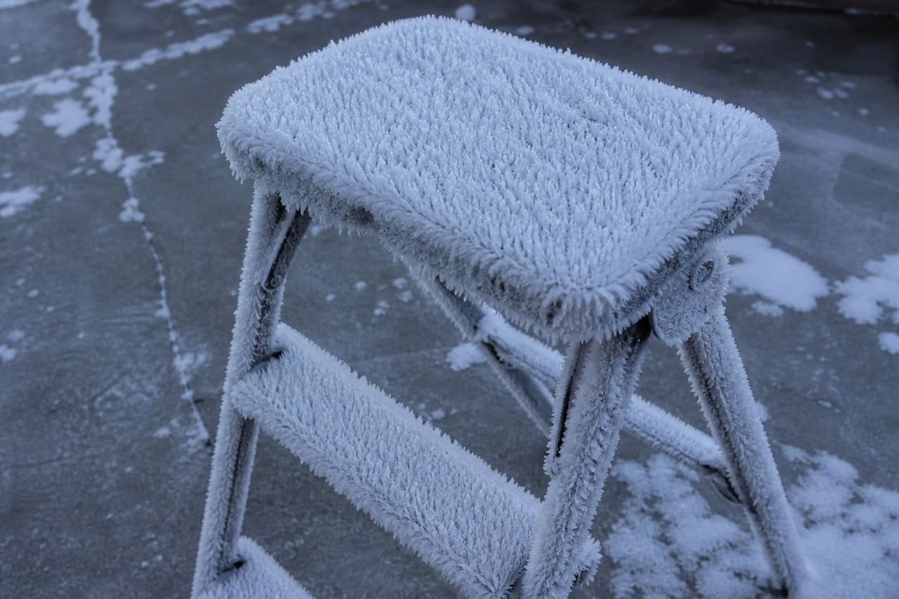 Metal Folding Step Stool Covered in Winter Frost
