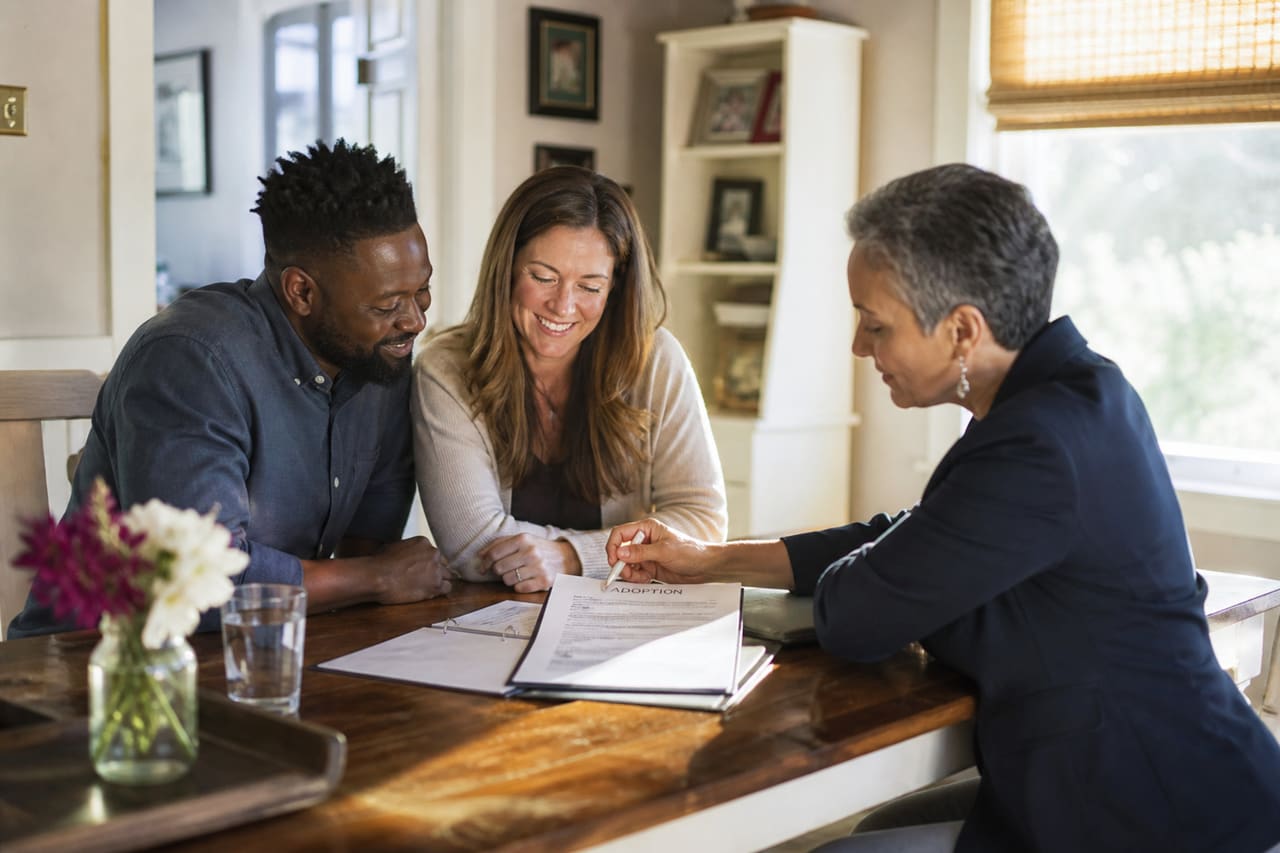 Adoptive Parents Reviewing Legal Documents with a Social Worker