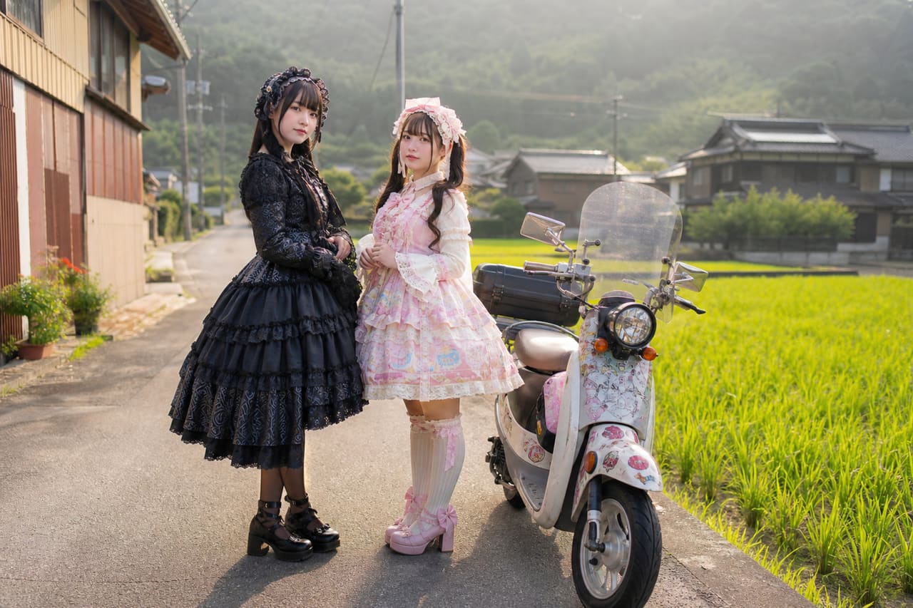 Two Women in Lolita Fashion Standing by a Scooter in Rural Japan