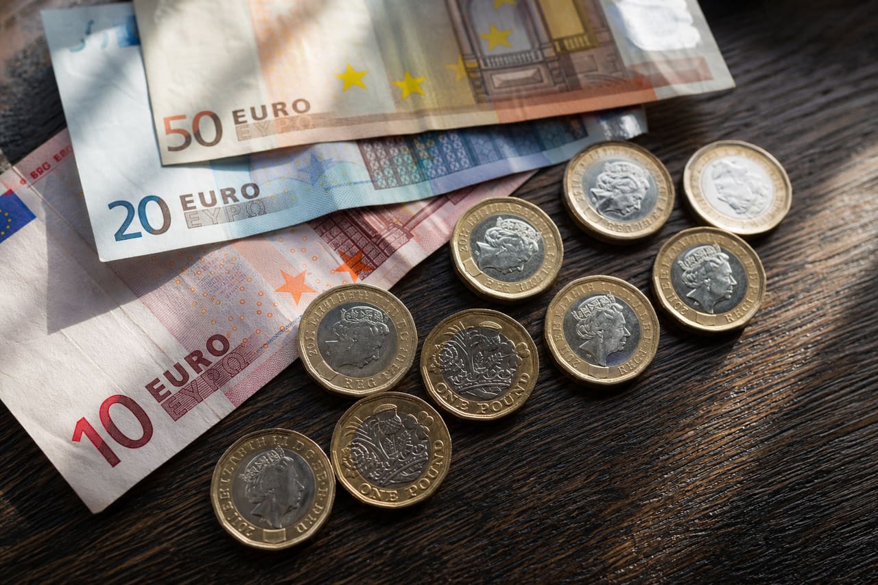 Euro Banknotes and British Pound Sterling Coins on Wooden Table